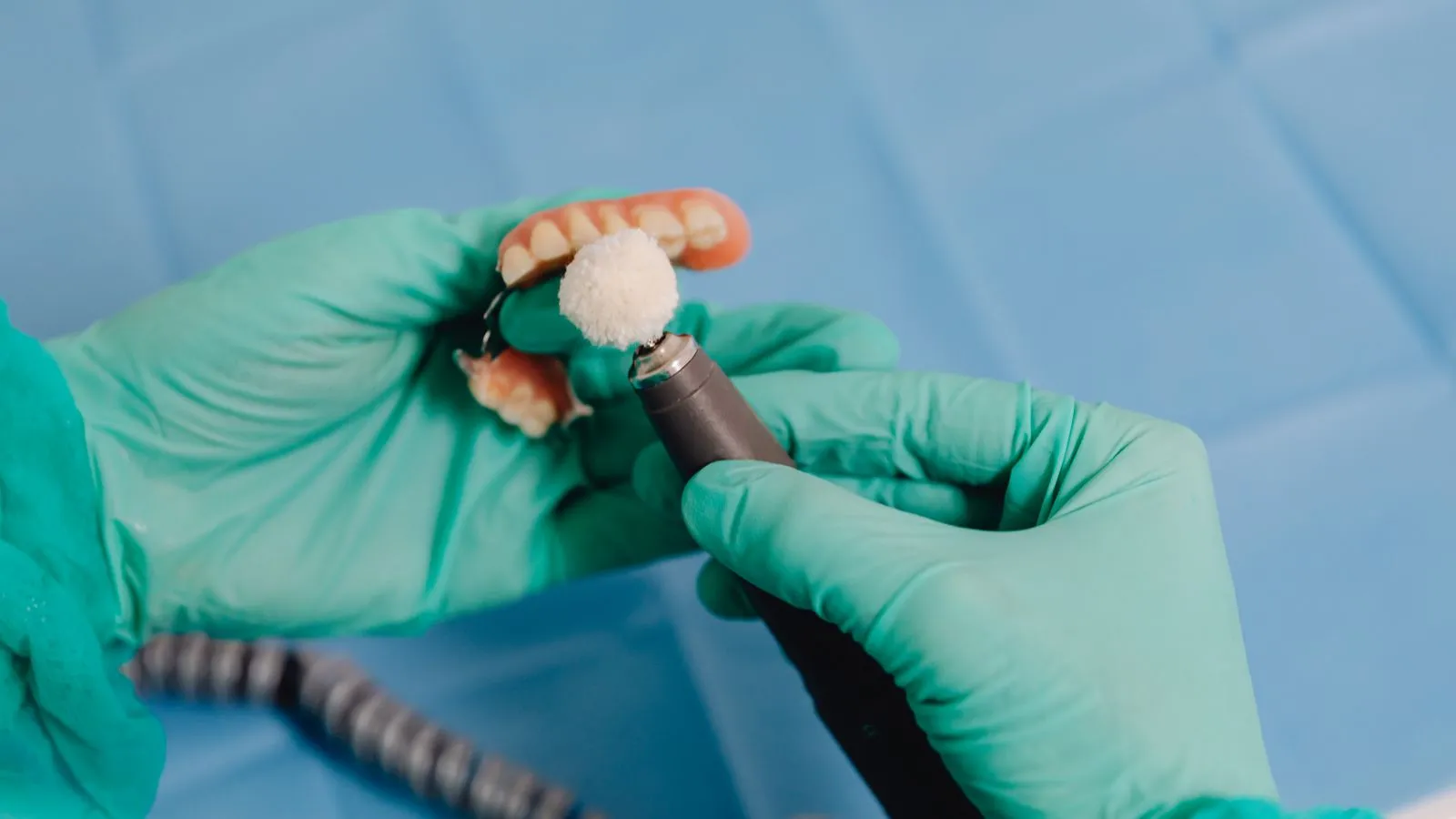A dental technician working carefully on a removable denture